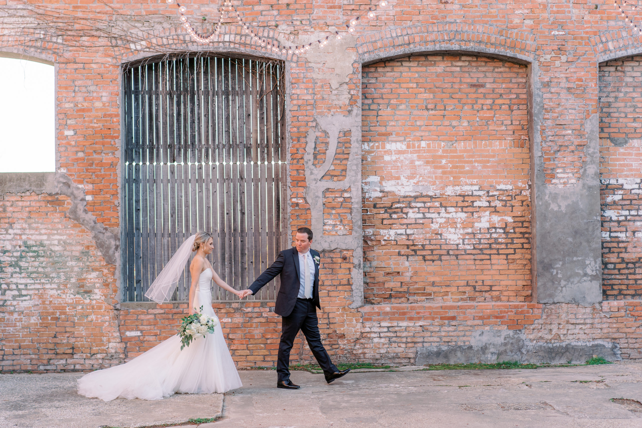 bride and groom walking in mckinney cotton mill