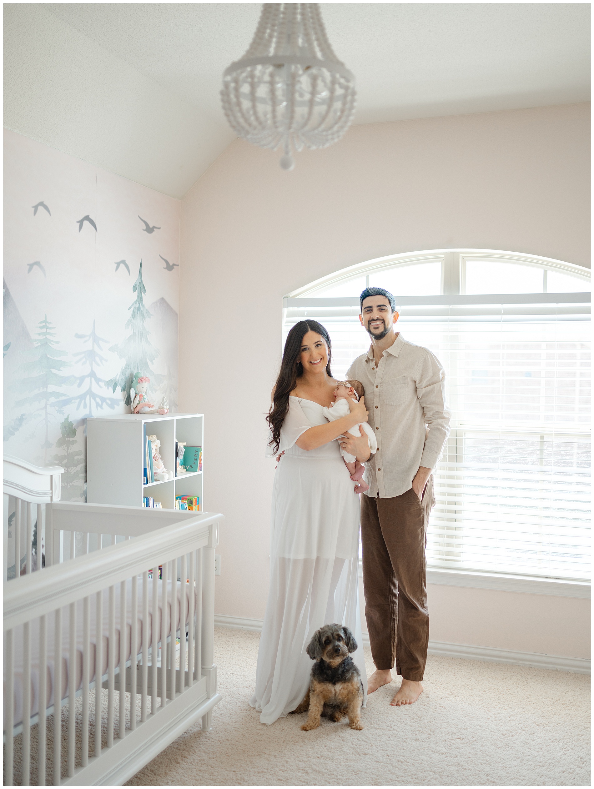 family holding their baby in the nursery during in-home newborn photos